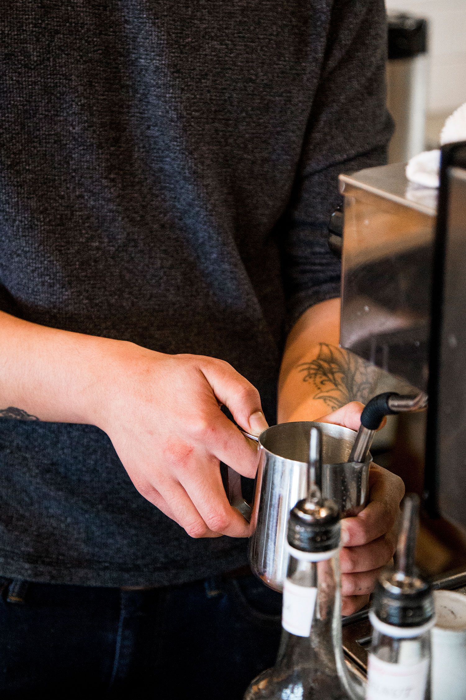 Barista steaming milk for a hot coffee drink